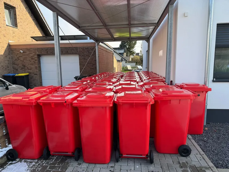 Rote Sammeltonnen in der Einfahrt der Werkstatt